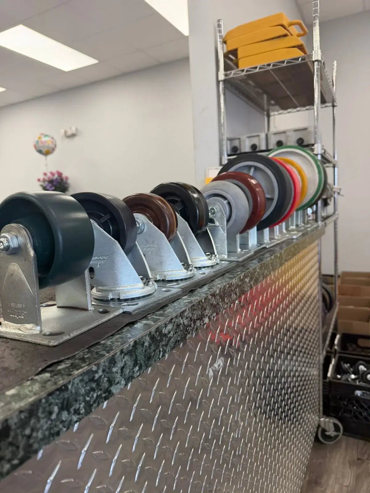 Industrial caster lineup on the Douglas Equipment Miami showroom counter — polyurethane, phenolic, and rubber wheels in stock