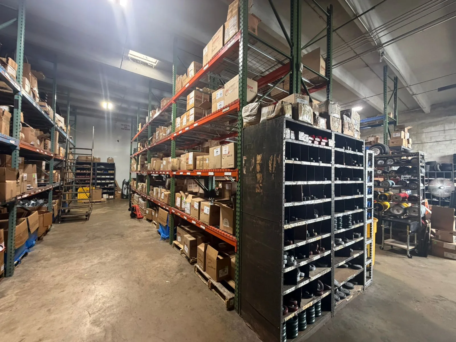 Inside the Douglas Equipment Miami warehouse — pallet racks stocked with Colson, Albion, Shepherd, MedCaster product